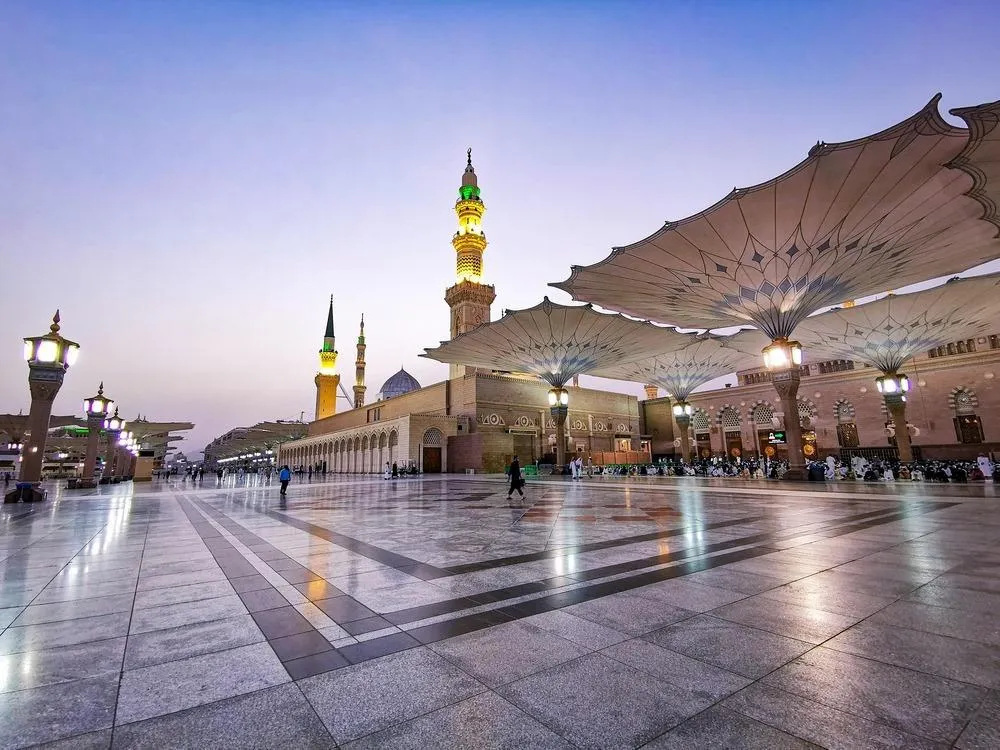 Prophet Mosque Medina plaza umbrellas at dusk