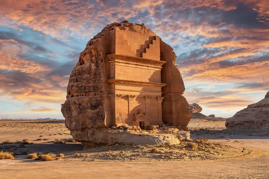 Qasr al Farid tomb AlUla desert under golden clouds