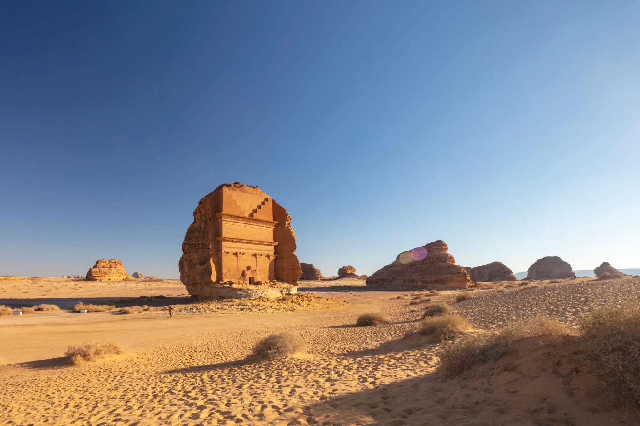 Ancient Qasr al Farid tomb Hegra AlUla under clear blue sky